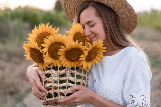 Foto vrouw met mand met zonnebloemen