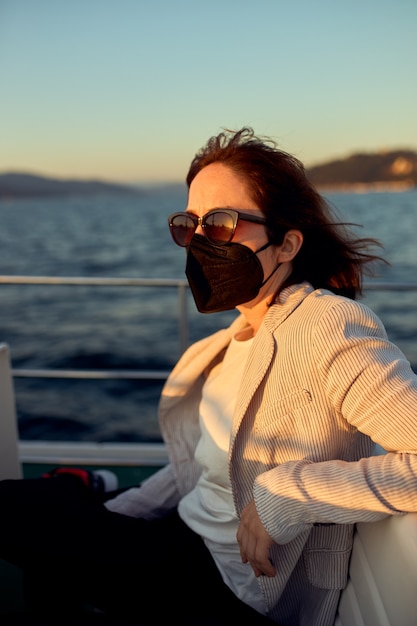 Vrouw met masker en zonnebril op een forenzenboot.