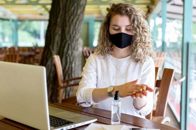 Foto vrouw met masker met handdesinfecterend middel