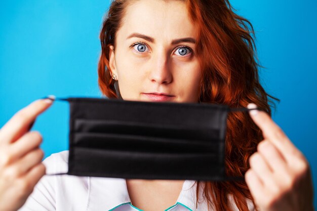 Foto vrouw met masker om mond en neus te bedekken om te beschermen tegen virussen op blauwe achtergrond.