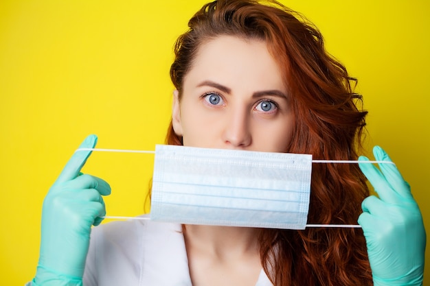 Vrouw met masker om mond en neus te bedekken om te beschermen tegen virussen op gele achtergrond.