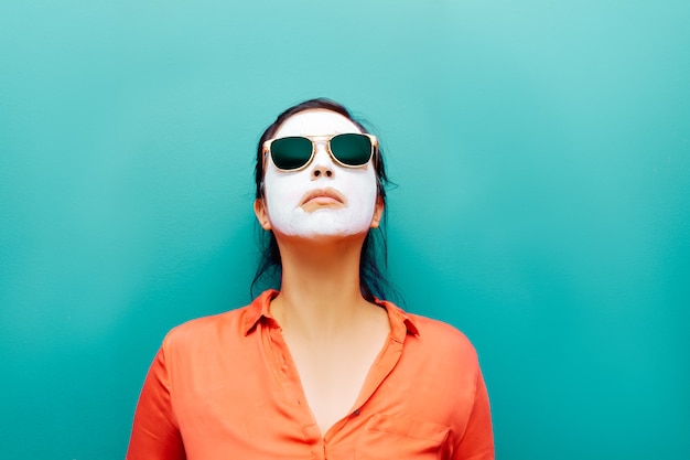 Vrouw met masker van de zonnebril het witte schoonheid op turkooizen achtergrond