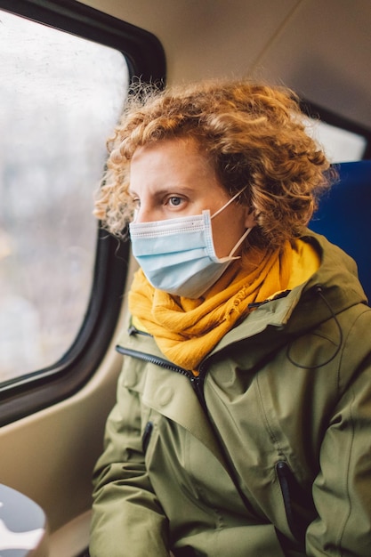 Vrouw met masker zit in de auto.