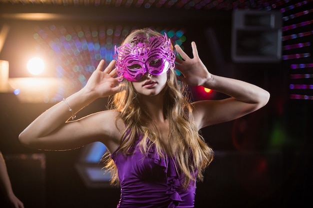 Vrouw met maskerade dansen op de dansvloer