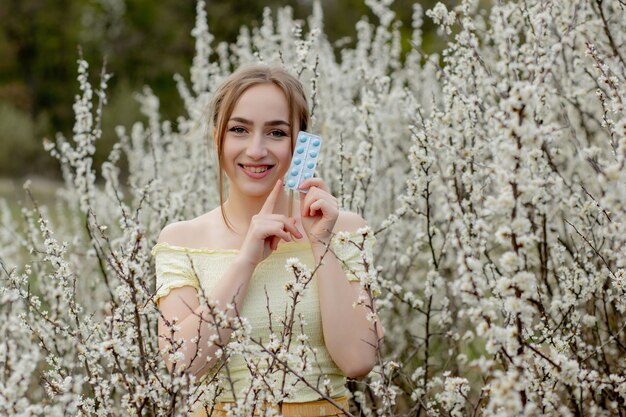 Vrouw met medicijnen in handen Fighting Spring Allergies Outdoor - Portret van een allergische vrouw omringd door seizoensbloemen