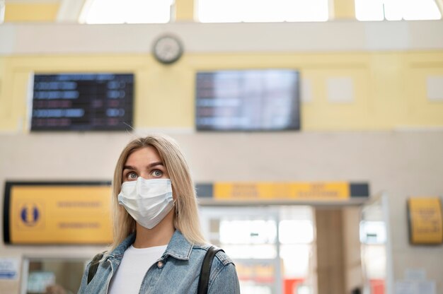 Vrouw met medisch masker op het openbare treinstation