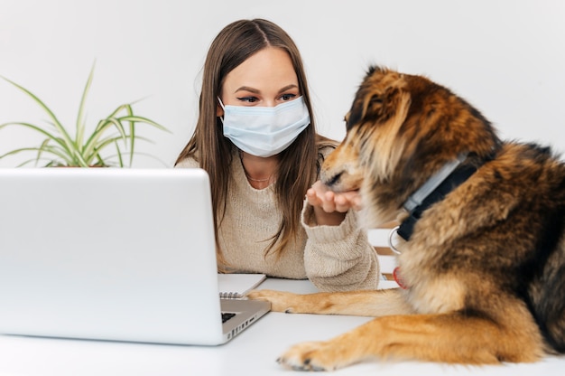 Foto vrouw met medisch masker spelen met haar hond
