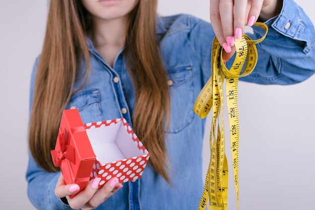 Vrouw met meetlint en geschenkdoos geïsoleerd