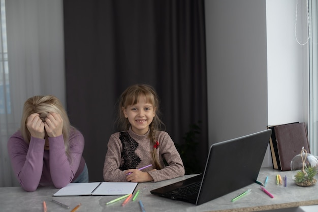 Vrouw met meisje huiswerk op laptop