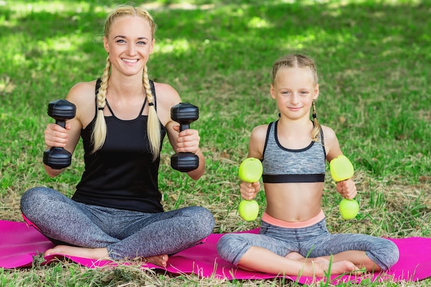 Vrouw met meisje traint in het park.