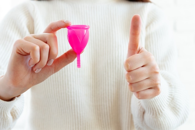 Vrouw met menstruatiecup in de hand