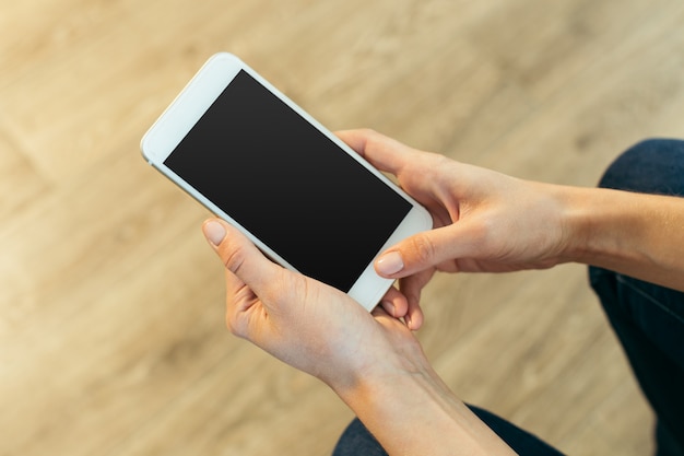 Vrouw met moderne mobiele telefoon in handen