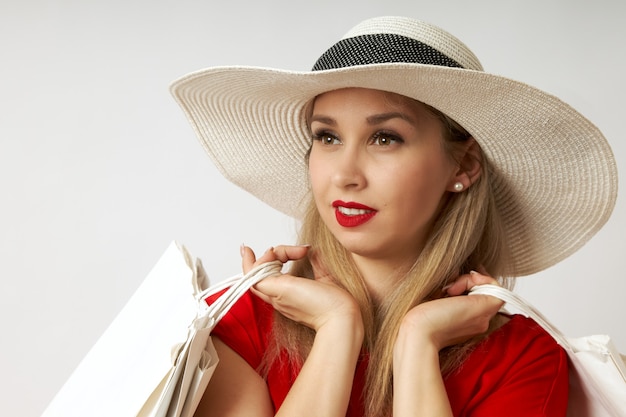 Vrouw met mooie ogen en een hoed kocht veel nieuwe dingen voor zichzelf