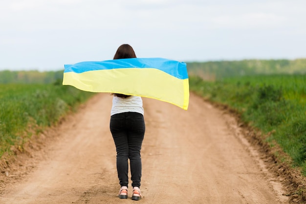 Vrouw met Oekraïense vlag in tarweveld Gelukkige vrouw die Onafhankelijkheidsdag viert