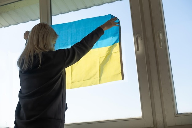 Vrouw met Oekraïne vlag. Stop de oorlog tussen Rusland en Oekraïne. Blijf bij Oekraïne. Bid en hoop op vrede en wereld. Ruimte kopiëren