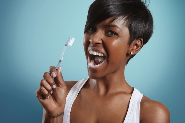 Vrouw met open mond met tandpasta poetst haar tanden