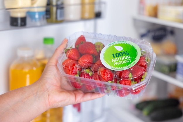 Foto vrouw met pakket ecologisch geteelde aardbeien concept van het eten van gezonde natuurlijke producten