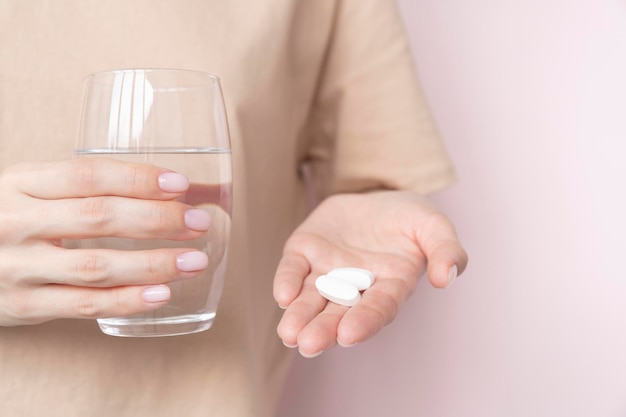 Vrouw met pillen en glas water