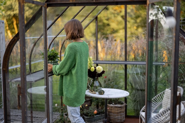 Vrouw met planten in kas