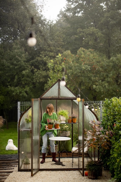 Vrouw met planten in kas