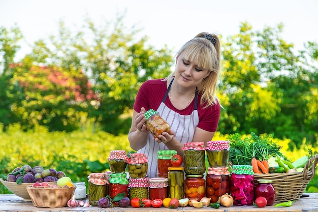 Vrouw met pot geconserveerde groenten voor de winter selectieve focus