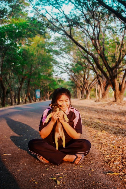 Vrouw met puppy terwijl ze op de weg zit