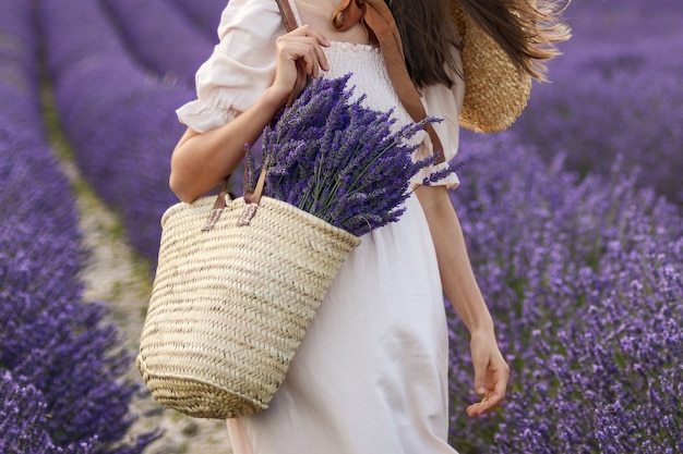 Vrouw met rieten mand met een lavendel in het veld