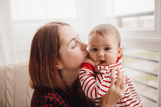 Vrouw met rode haren kussen vrij kleine jongen