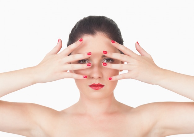 Vrouw met rode lippen en rode geschilderde vingerspijkers over gezicht