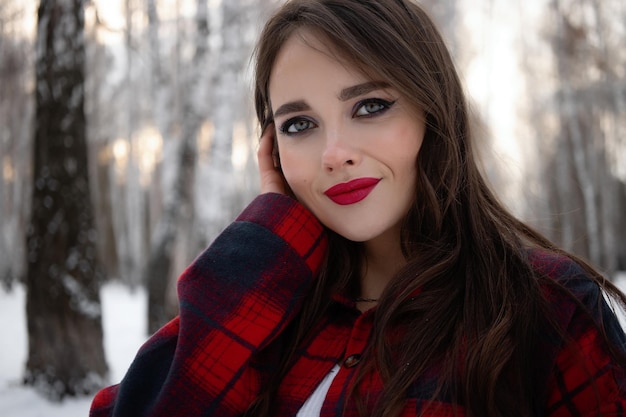 Vrouw met rode lippen in winterbos