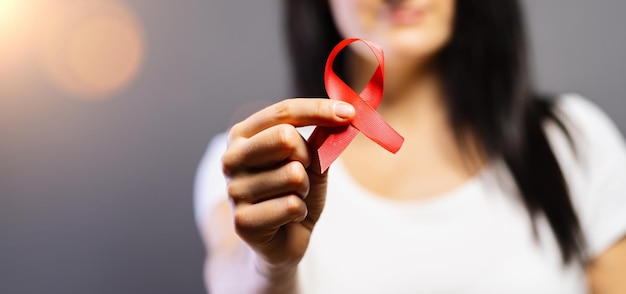 Vrouw met rood aids- of hiv-lint bewustmakingsconcept voor borstkanker