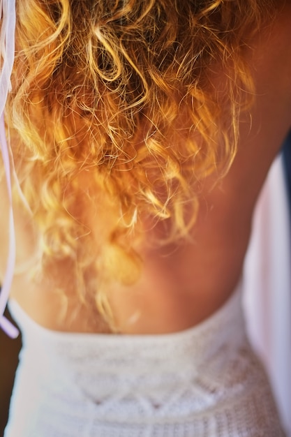 Vrouw met rood krullend haar in witte zomerjurk. Roodharig meisje met bleke huid, helder ongewoon