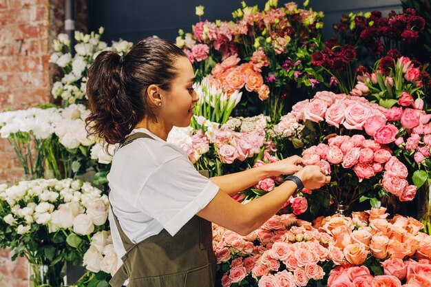 Vrouw met roze bloemen tegen planten