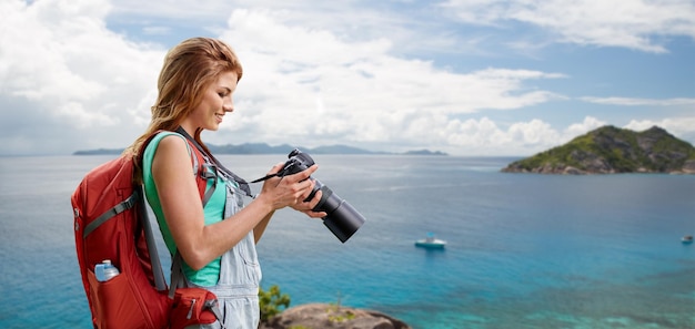 Foto vrouw met rugzak en camera over strand