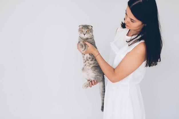 Vrouw met schattige grijze kat op handen