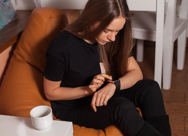 Vrouw met slim horloge in café in zwarte tshirt