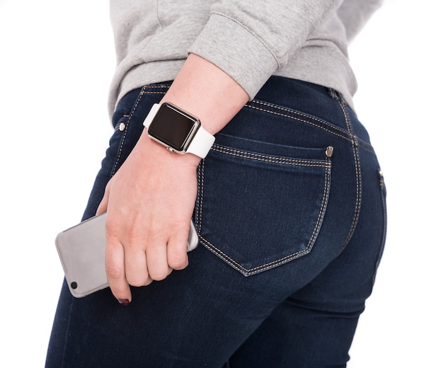 Vrouw met slimme horloge en smartphone op een witte achtergrond.