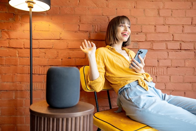 Vrouw met slimme speaker en telefoon thuis