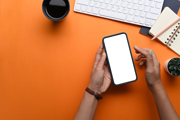 Vrouw met slimme telefoon op haar bureau