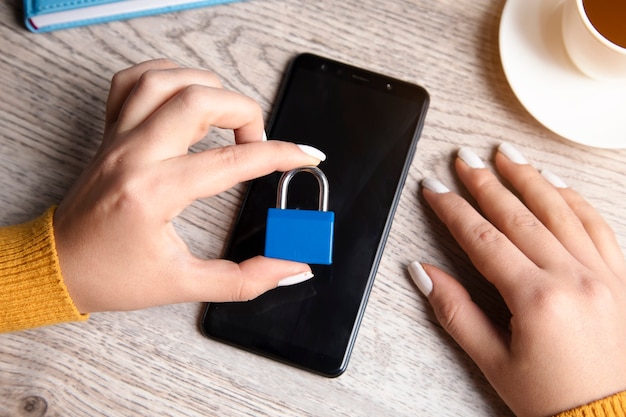 Vrouw met slot op telefoon op tafel