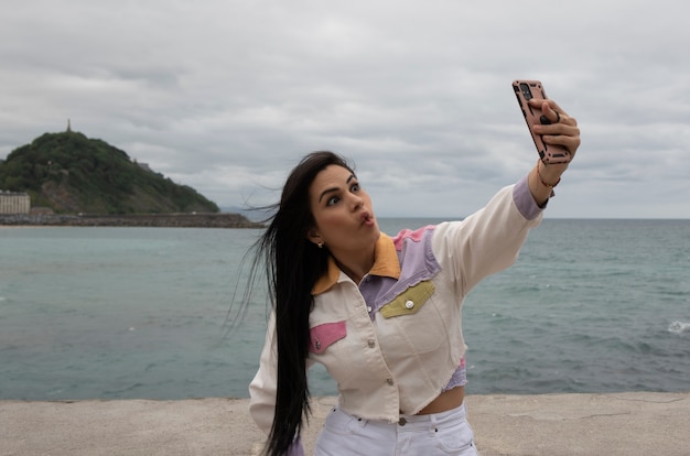 Vrouw met smartphone die selfies op straat maakt