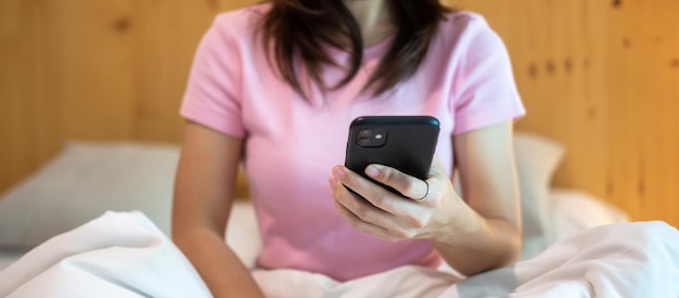 Vrouw met smartphone voor sociale media jonge vrouw films kijken via mobiele telefoon op bed thuis technologie netwerk online winkelen e-commerce levensstijl en digitaal communicatieconcept