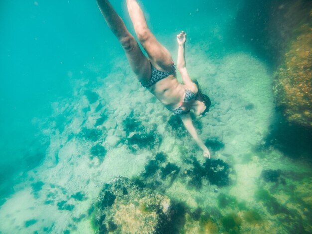 Vrouw met snorkelmasker onder water