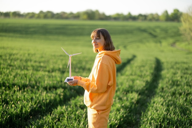 Vrouw met speelgoed windgenerator op groen veld