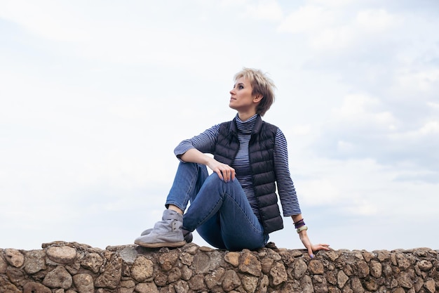 Vrouw met spijkerbroek in de buurt van zee in de herfst