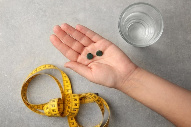 Vrouw met spirulina-pillen boven tafel