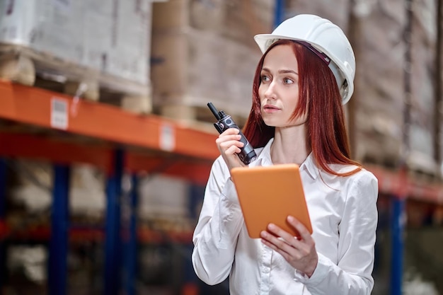 Vrouw met tablet bespreken werkmoment op walkie-talkie