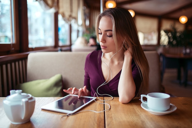 Vrouw met tablet-pc met behulp van internet in restaurant.