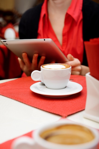 Vrouw met tabletcomputer in koffiewinkel