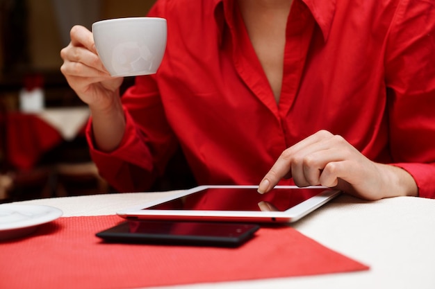 Vrouw met tabletcomputer in koffiewinkel